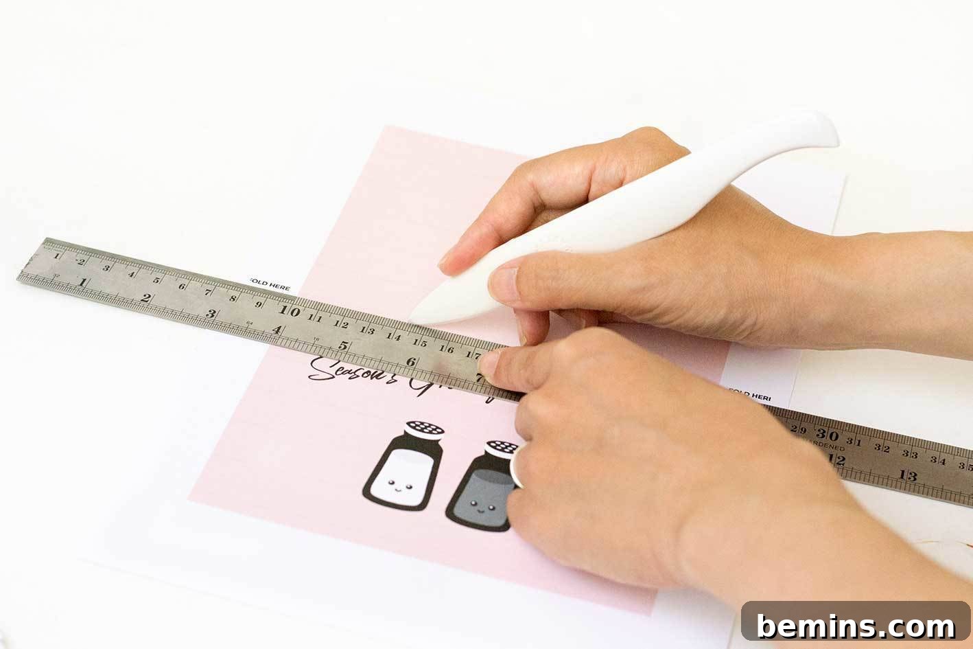 Scoring the Christmas cards with a bone folder and ruler.