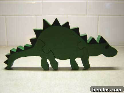 A green wooden dinosaur puzzle sits on a table