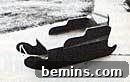 A vintage wooden snow sled on a snowy sidewalk