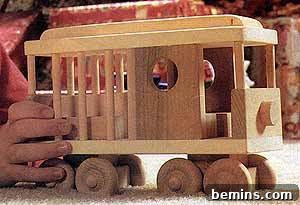 A child pushing a wooden toy cable car