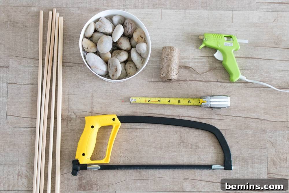 A glue gun and other tools near a cup full of rocks.