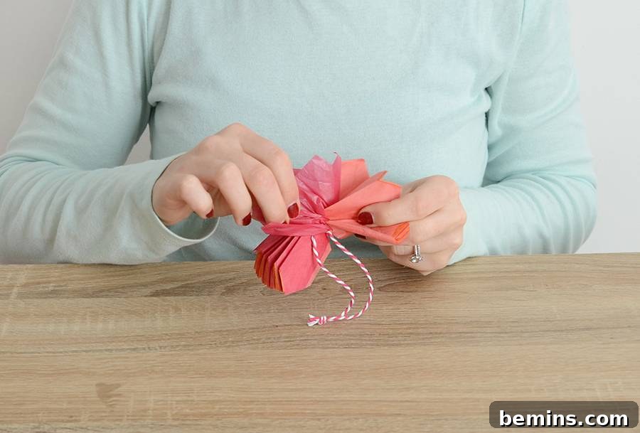 Securing the Accordion Fold with String for Pom Pom Ornament