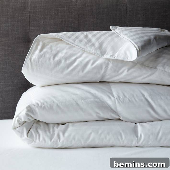 Creating a Haven: Elevate Your Bed to Ultimate Comfort 4 Fluffy white comforter folded on top of white sheets, showcasing a clean and inviting bedding arrangement.