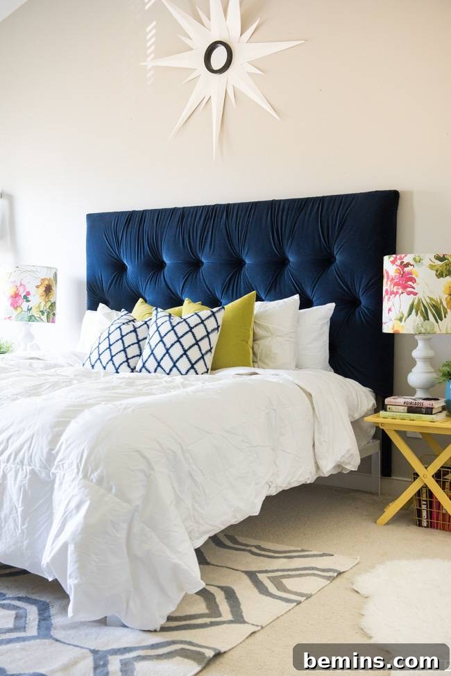 Creating a Haven: Elevate Your Bed to Ultimate Comfort 5 Large bed with a white comforter and navy blue tufted headboard in a stylish and comfortable bedroom.