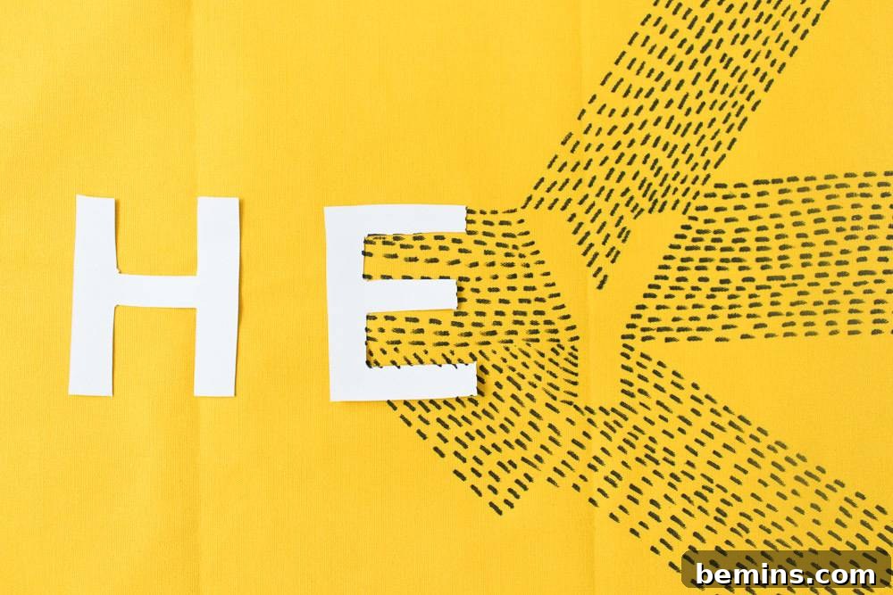 Words spelled out in white on a yellow background. The typographic design is taking shape.