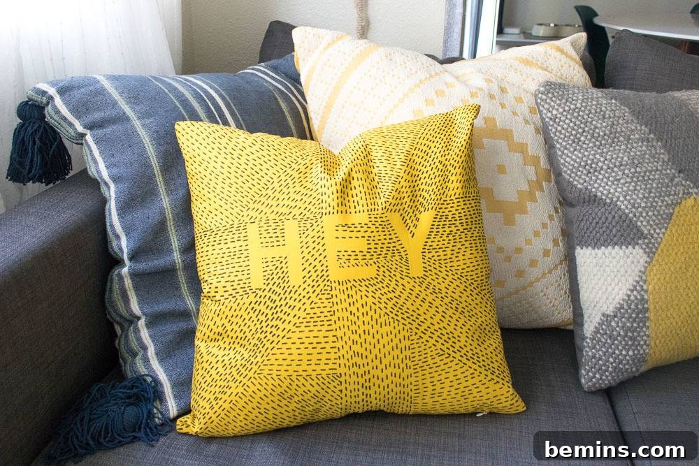 cute pillows with various colors - the finished DIY typographic throw pillow displayed with other decorative pillows.