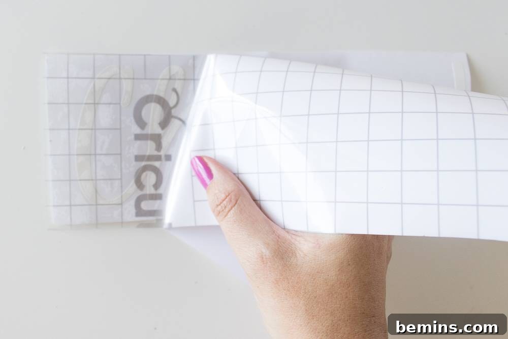 A person holding a white paper label with custom text ready to be transferred.