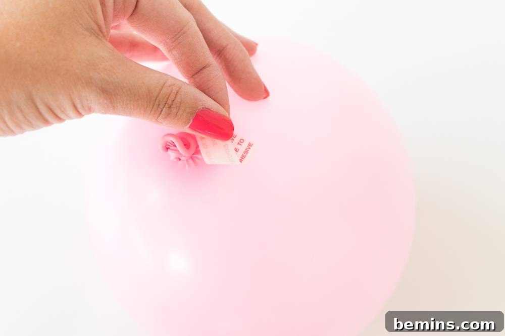 Applying tape on a pink balloon