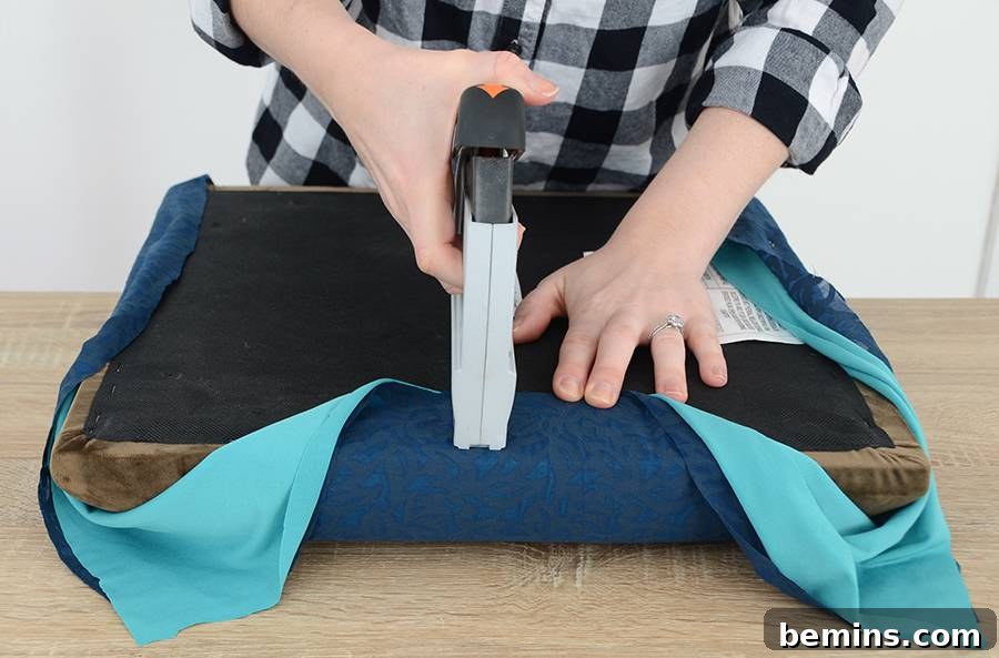 Effortless Ottoman Upgrade: A Simple DIY Transformation 7 Securing the Corners of the Ottoman Fabric