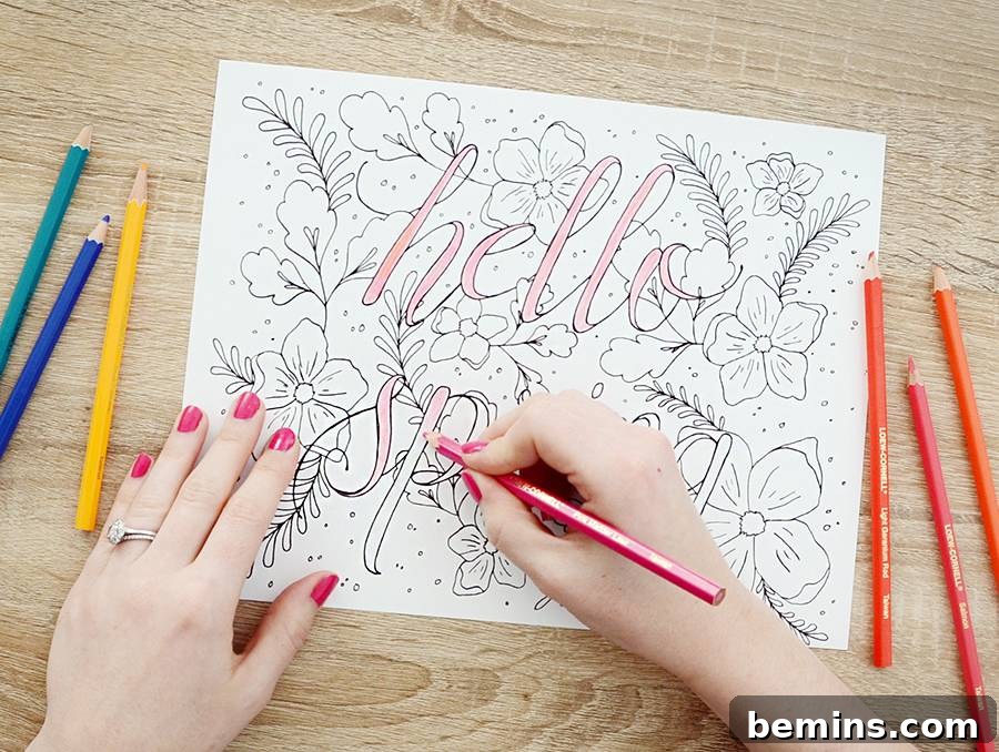 Someone is using colored pencils to color in a picture. Focused hand carefully adding color to the intricate floral details.