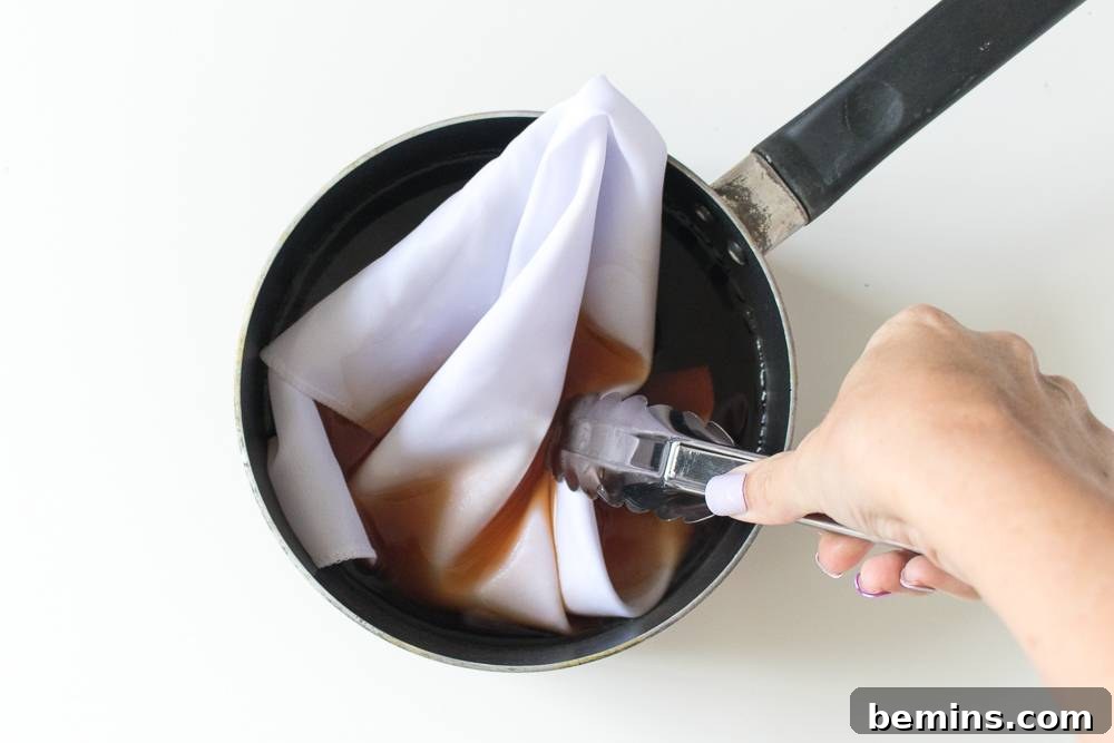Dipping a cotton cloth into a dye bath, a crucial step in the natural dyeing process.