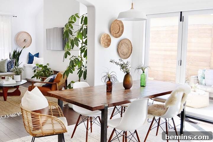 Boho meets mid-century modern living room with a vintage credenza, patterned rug, and stylish plants by K Dion Design.