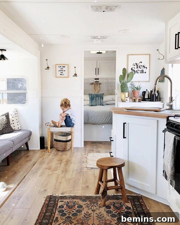 Interior of a beautifully renovated RV, showcasing a minimalist yet cozy bohemian family living space by Arrows and Bow.