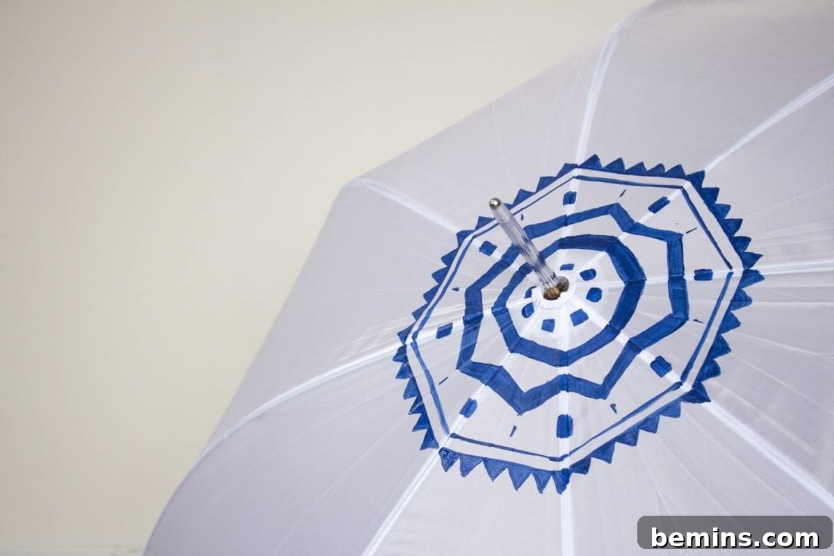 Close-up of a blue design on a white umbrella