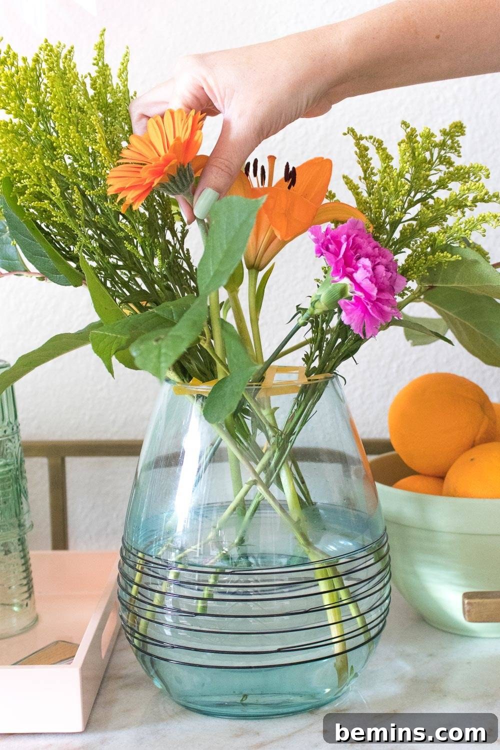 Turning Everyday Grocery Store Flowers into Stunning Floral Art 7 Adding filler flowers to the arrangement.