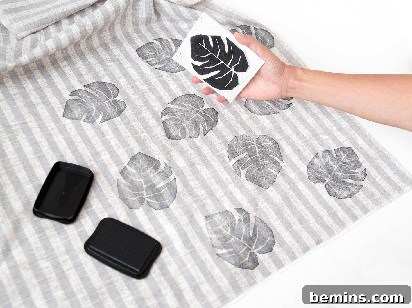 Stamping the fabric with the leaf design.