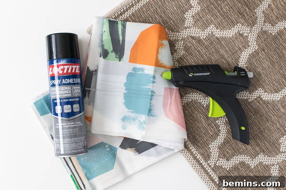 IKEA Shower Curtain Rug DIY: Budget-Friendly Outdoor Decor 4 Spray paint, tissue paper, and a drill arranged on a surface, indicating the tools and materials required for various DIY projects, including the outdoor rug.