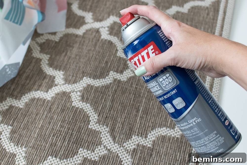 IKEA Shower Curtain Rug DIY: Budget-Friendly Outdoor Decor 6 A person holding a spray bottle, likely demonstrating the application of adhesive spray in a DIY or crafting project.