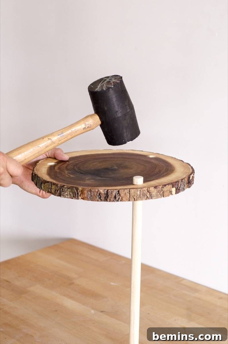 Using a mallet to add the legs to the plant stand