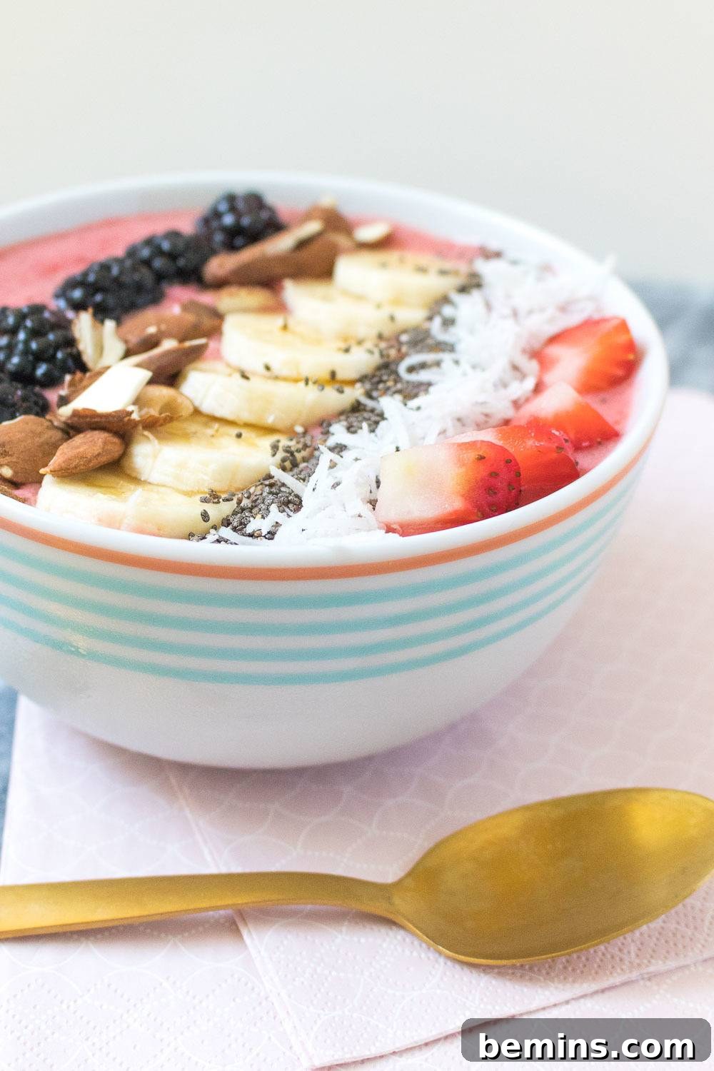 A close-up of a smoothie bowl with toppings like fruit and seeds