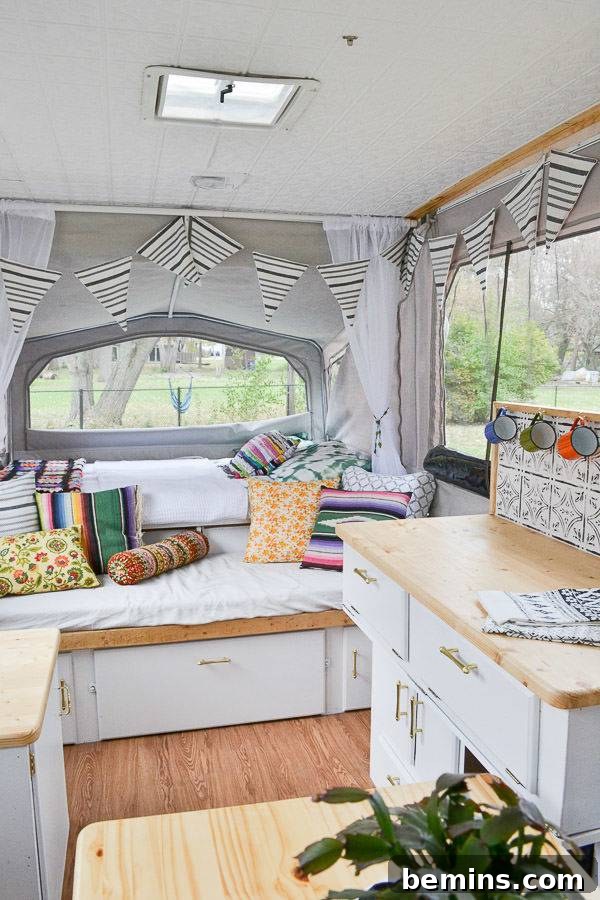A clean and organized pop-up camper interior, decorated with colorful accents and flea market finds.