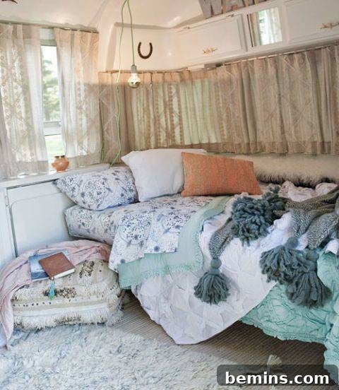 A small camper bed adorned with a light blue comforter and colorful pillows, creating a cozy and inviting space.