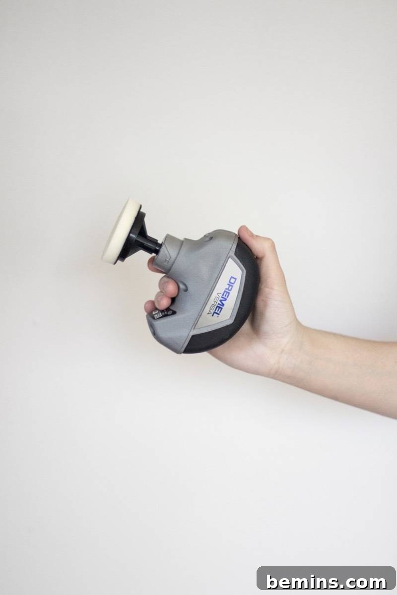 This Gadget Will Revolutionize Your Home Cleaning 7 Close up of woman's hand holding the Dremel Versa cleaning tool