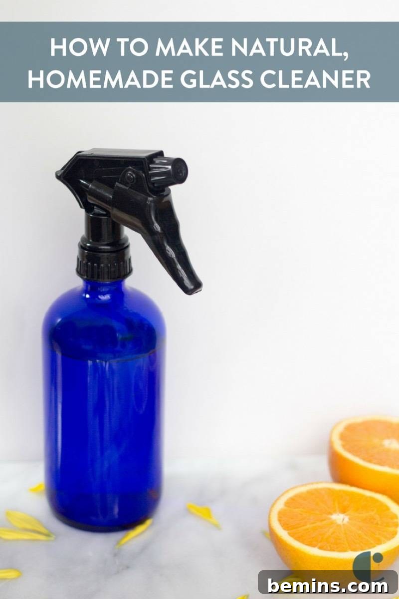 Homemade window cleaner in a spray bottle with clean windows in the background