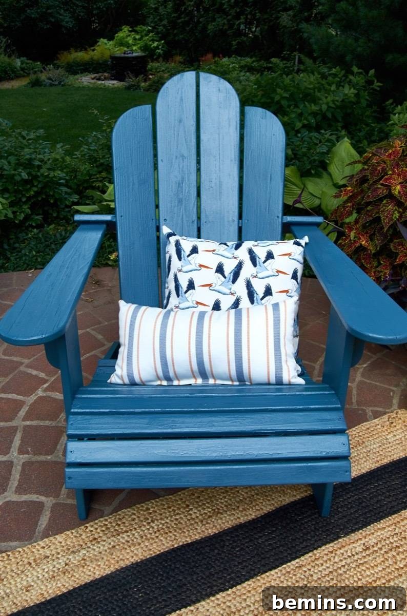 Summer-Ready Patio: A Fast & Fun Refresh 13 A blue lawn chair on a rug and stones with pillows on it.