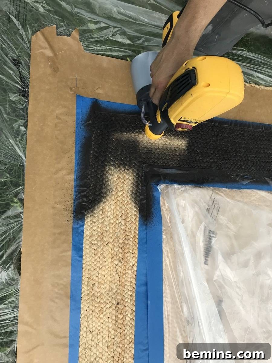 Summer-Ready Patio: A Fast & Fun Refresh 10 A person uses a paint brushing machine to put black paint on some wood.
