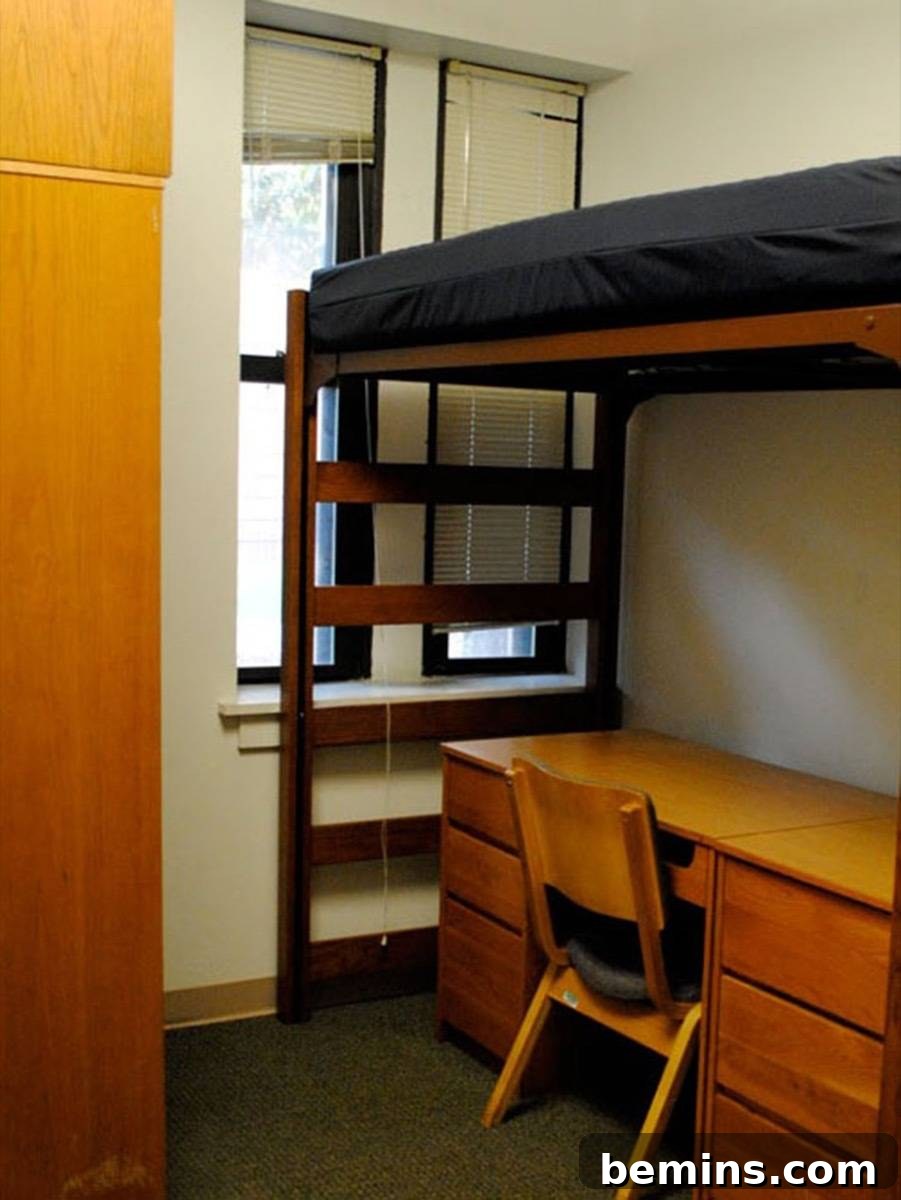 Before: Wooden desk sitting at the base of a bunk bed set in a college dorm room.
