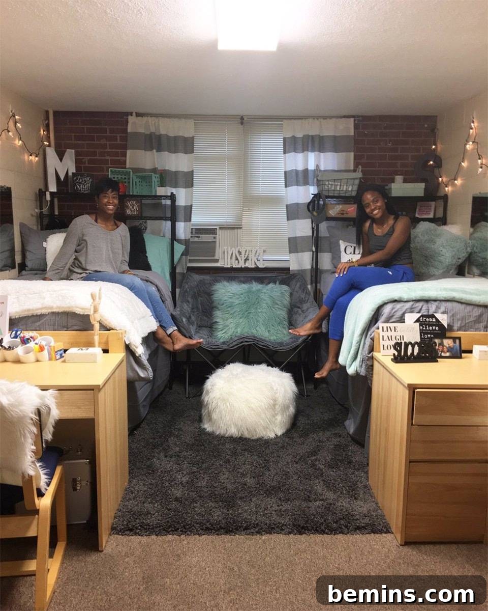 After: Two roommates sitting on two bed in a small dorm.