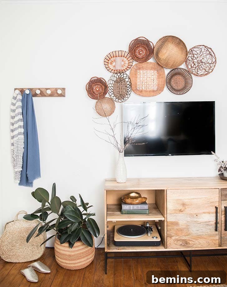 Wall-mounted flat screen TV above low furniture, baskets, and a coat hook.