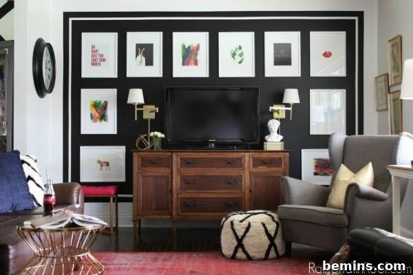 Living room with flat screen TV, artwork, gray chair, and a pink area rug.