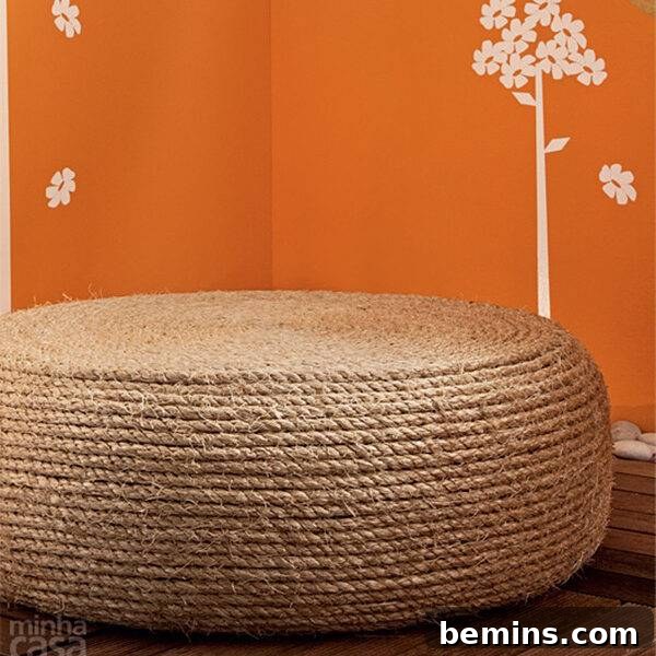 A light brown ottoman is next to an orange wall.