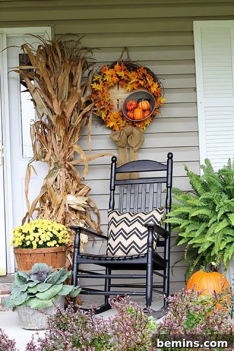 A front porch featuring winter cabbage and ferns surrounding an inviting rocking chair, creating a cozy and welcoming space