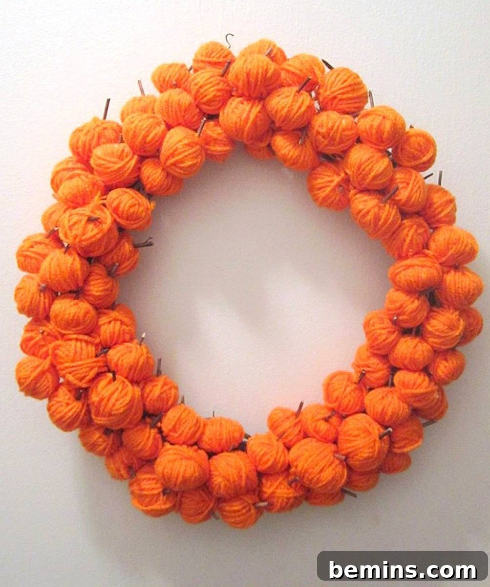 A yarn pumpkin wreath, a pretty and easy-to-make addition to your fall decor