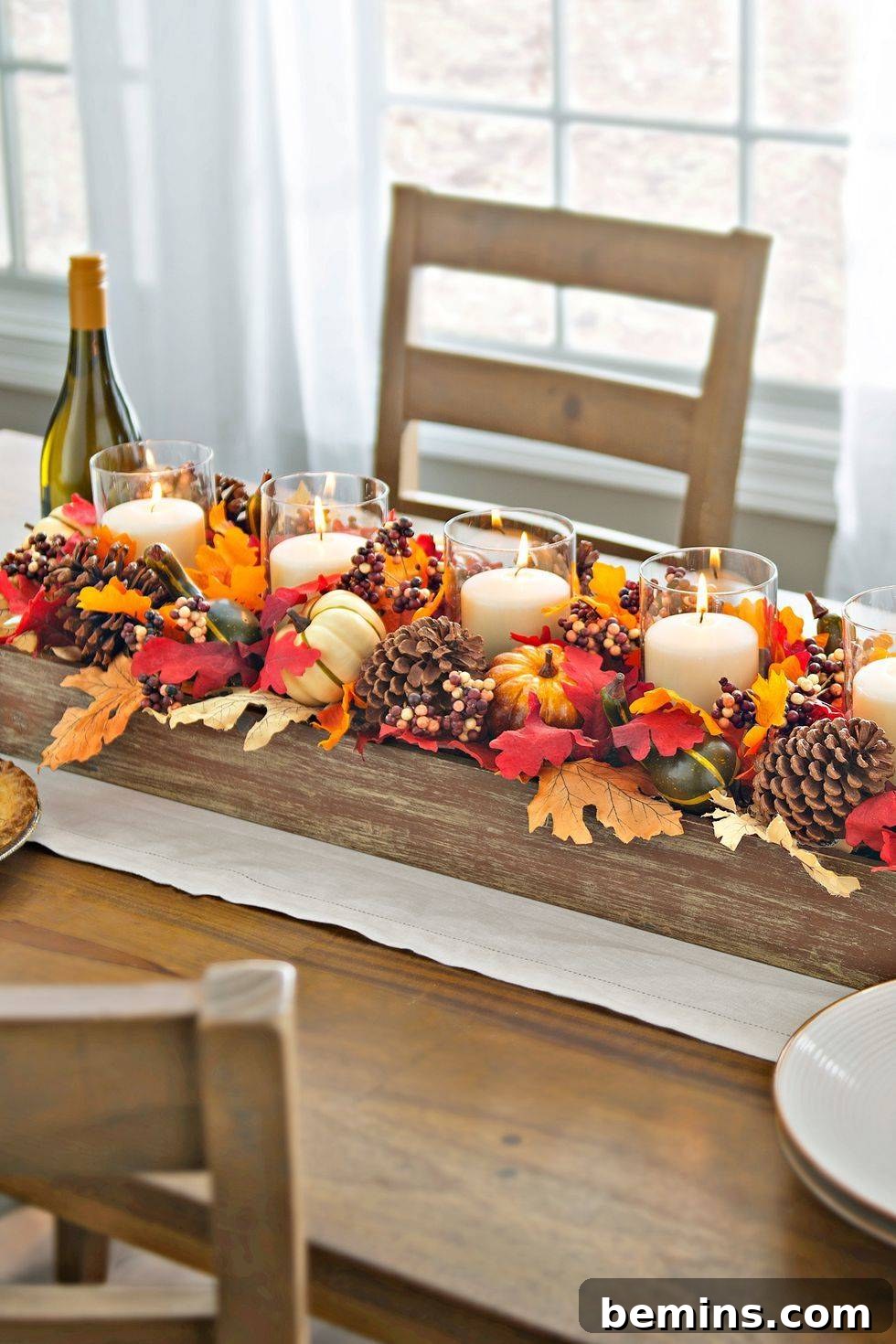 A fall tabletop centerpiece with pumpkins and candles, creating a warm and inviting ambiance