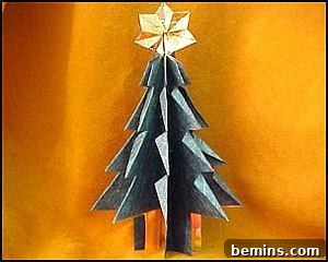 A small, folded origami Christmas tree with a large gold star on top.