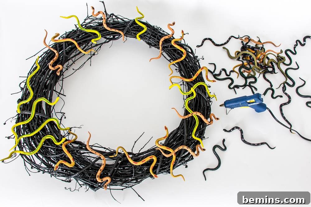 Glue the plastic snakes to the grapevine wreath
