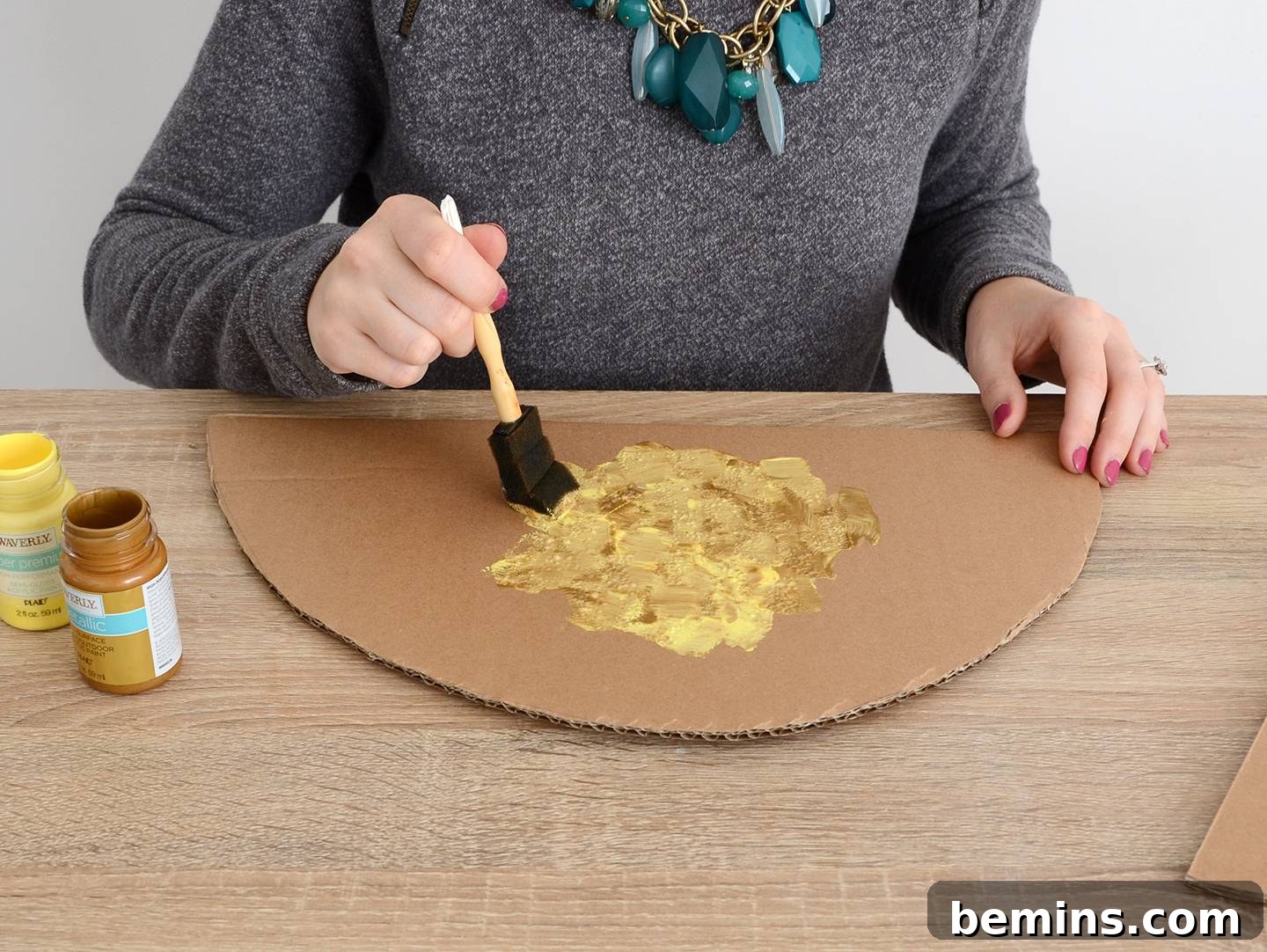 Painting the cardboard taco shells with gold and yellow paint