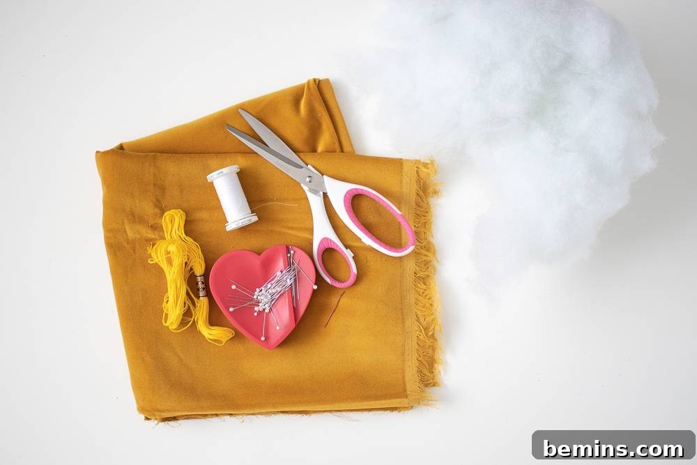 Folded yellow fabric with various crafting materials on top.