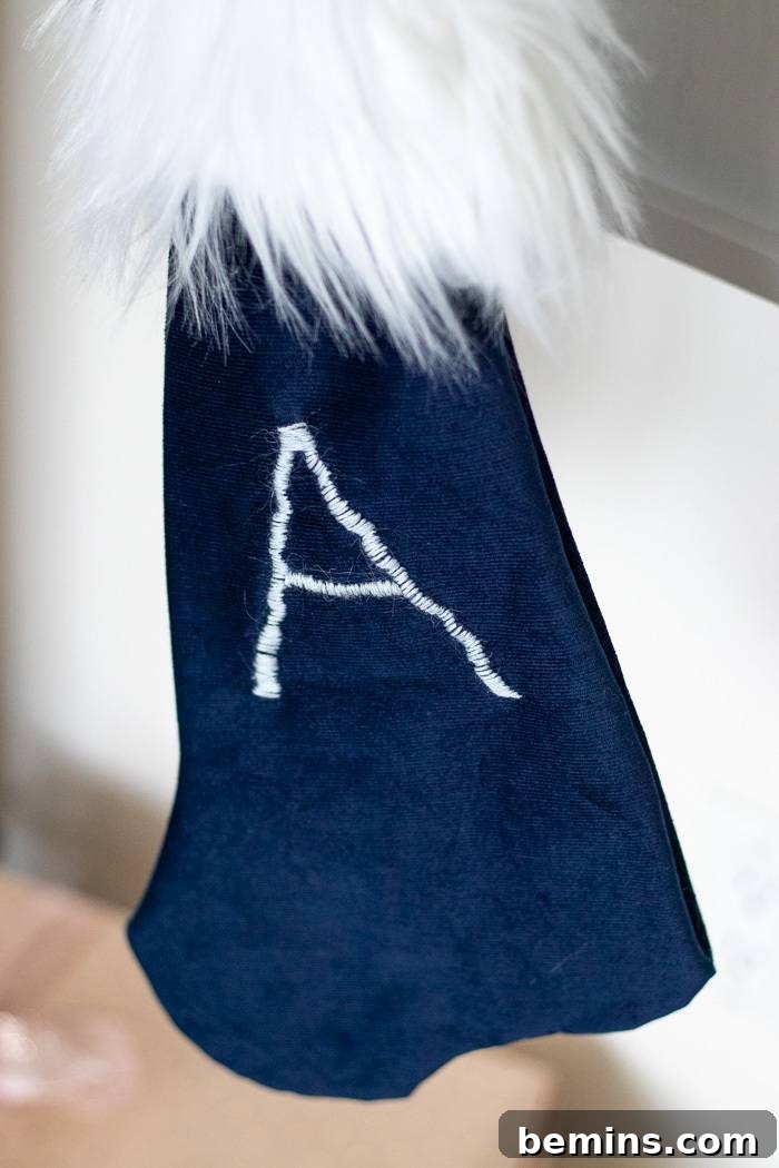 Navy blue stocking with white fur and the letter A embroidered on the front.