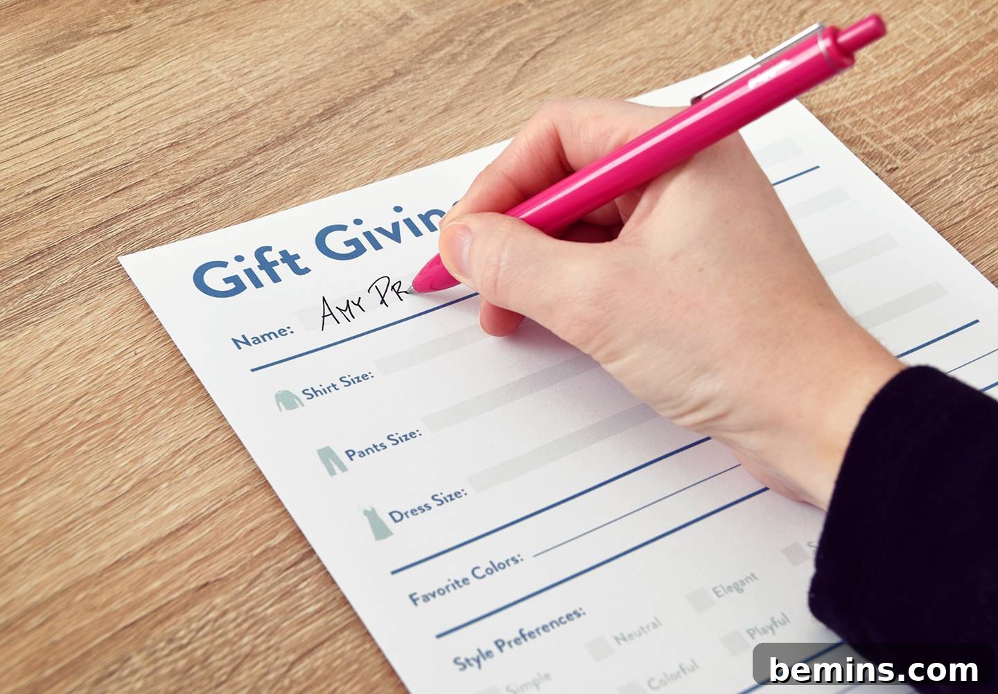 Person is writing on a gift giving sheet using pen.