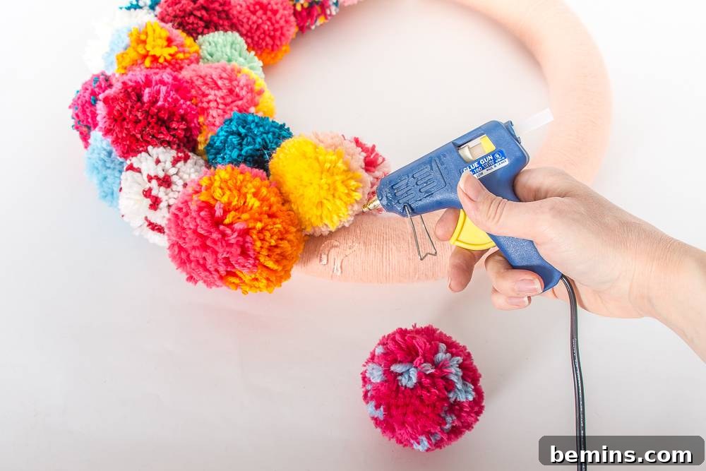 A Vibrant Boho Holiday Pom Pom Wreath 7 Glue the pom-poms to the wreath form