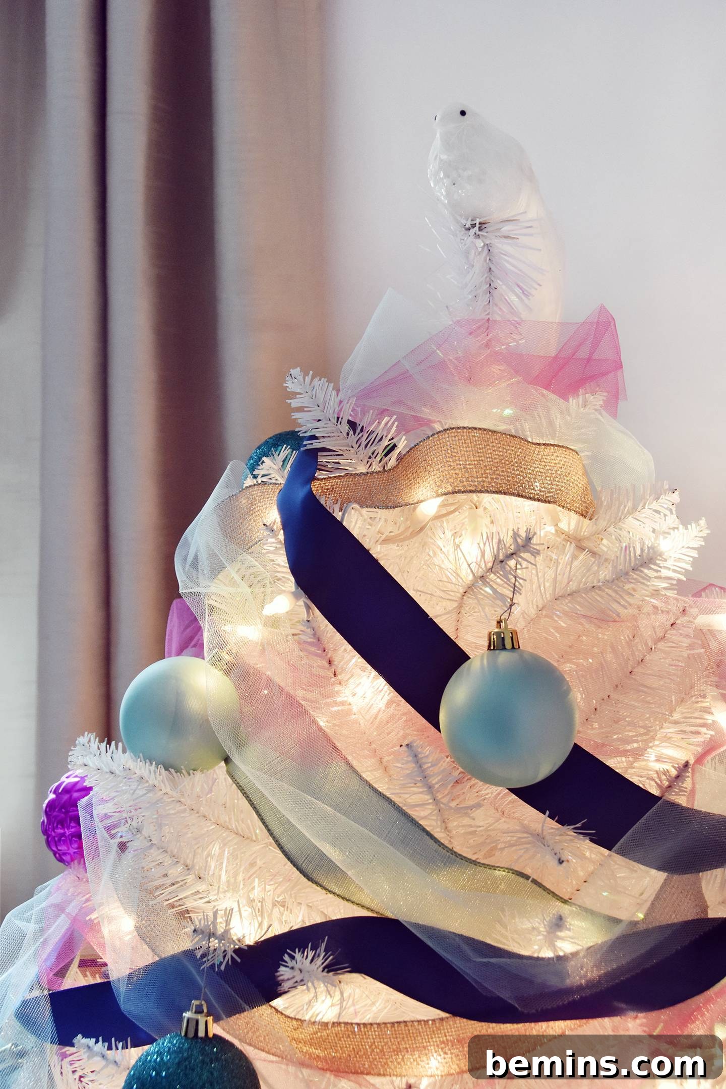 Bird ornament on top of a Christmas tree