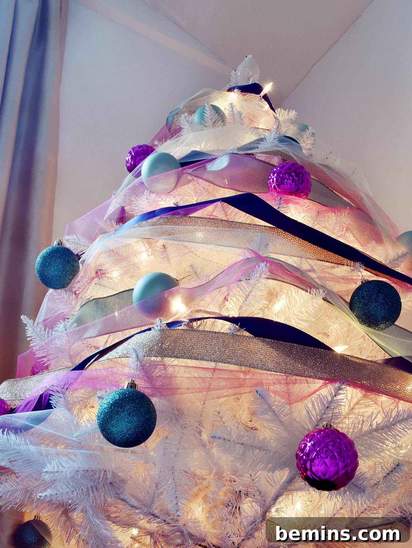 Fully decorated Christmas tree with ribbon and ornaments