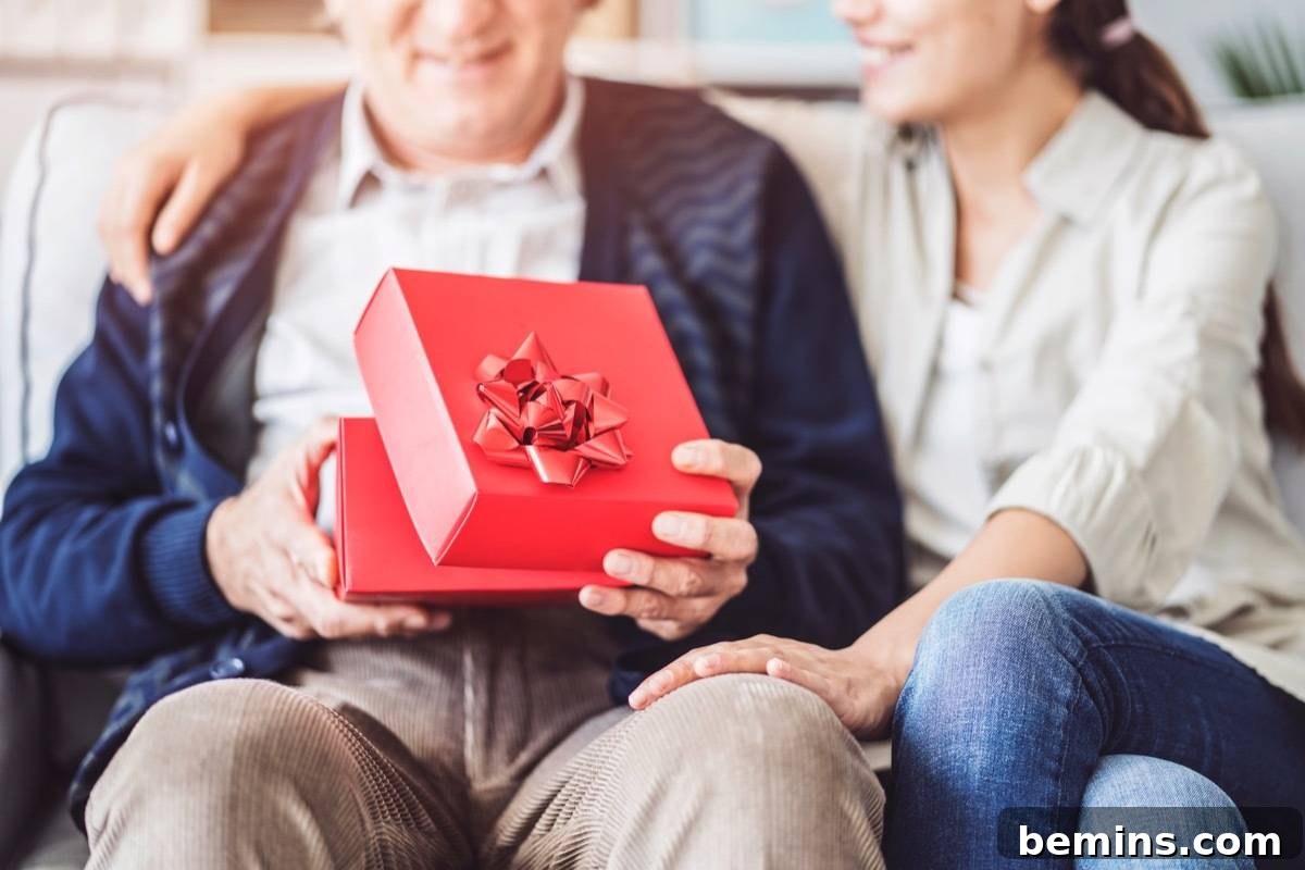A young daughter giving her father a Christmas gift with a smile.