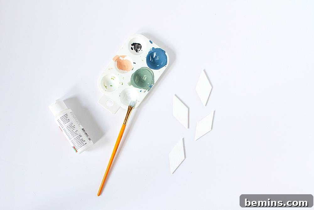 A paint brush resting on a paint holder with several colors of paint in it.