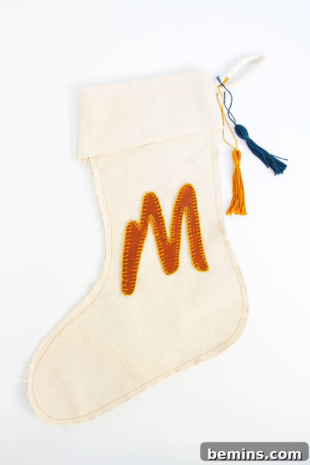 A natural colored stocking with the letter M in orange.